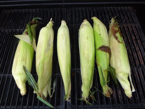 corn on the cob in the husk on the grill