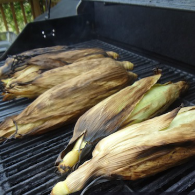 corn on the cob on the grill in the husk
