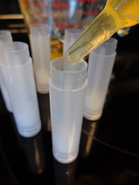 medicine syringe filling chapstick containers with melted chapstick