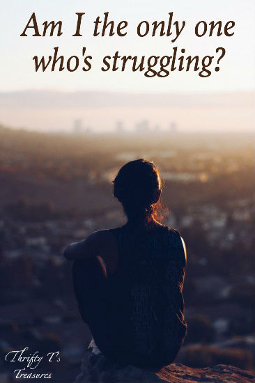 silhouette of a woman sitting looking over a city at sunset