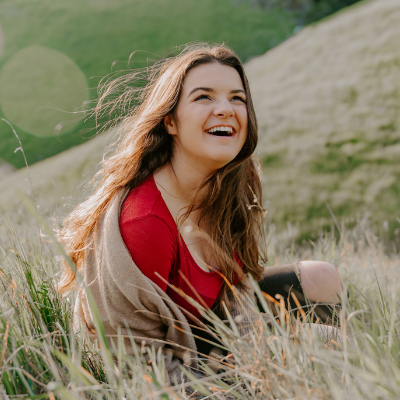 smiling woman sitting in field