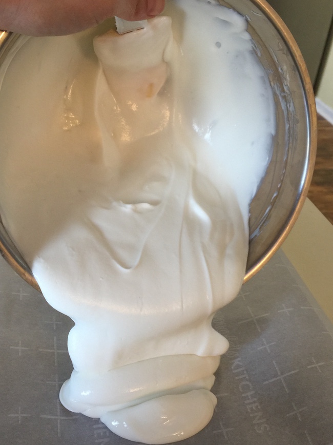 yogurt being poured into a pan lined with parchment paper