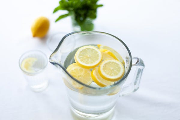 pitcher of water with lemons on top