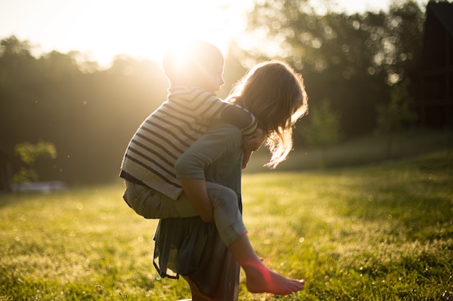 little boy riding piggy-back on moms back