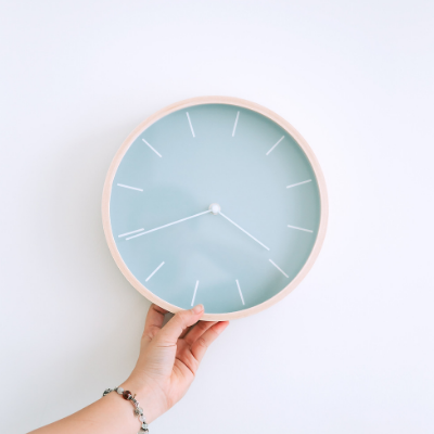 hand holding clock with blue face