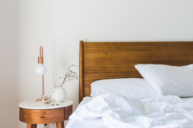 bed with white bedding and night stand