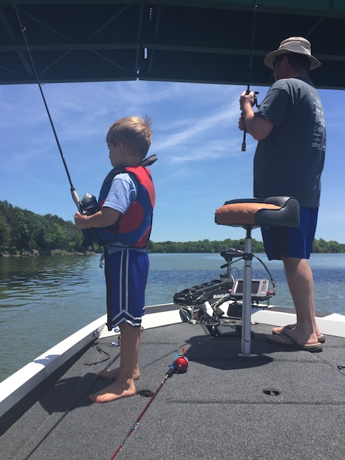 father and son fishing on a boat