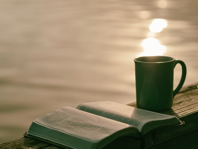 bible and coffee mug on dock