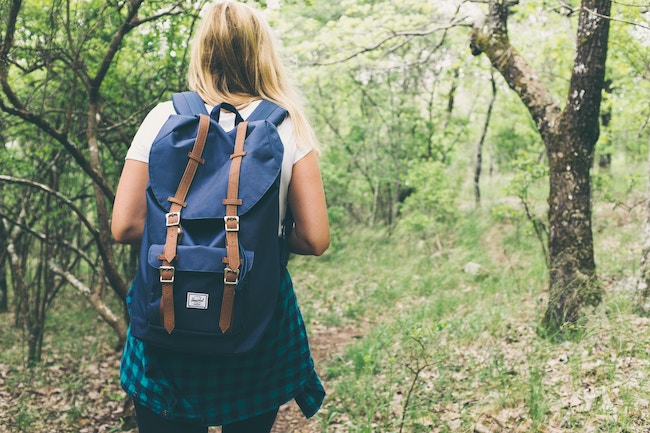 female hiking through woods