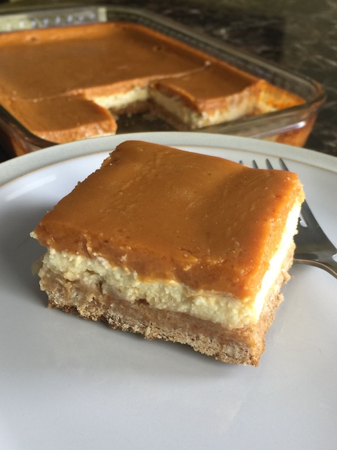 pumpkin cheesecake bar on plate beside pan