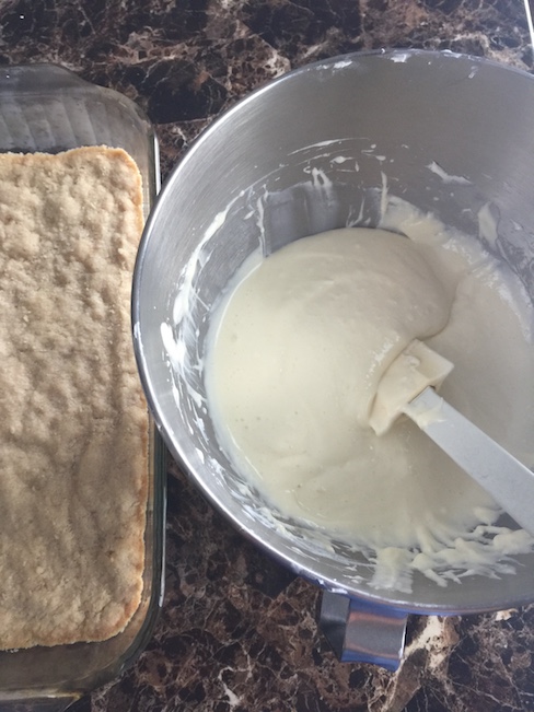 cream cheese mixture beside cake mixture in pan