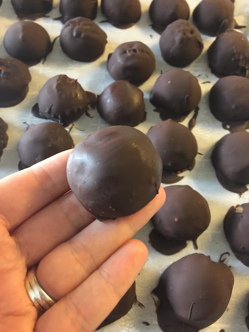 baking sheet full of chocolate covered peanut butter balls
