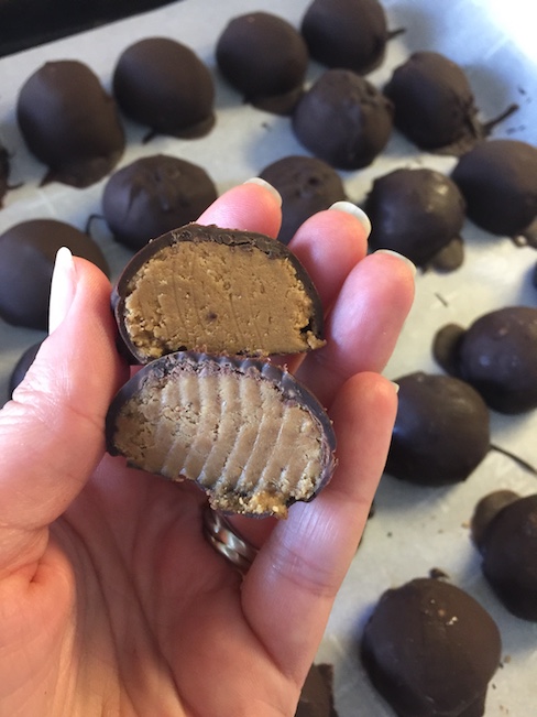 hand holding chocolate covered peanut butter balls