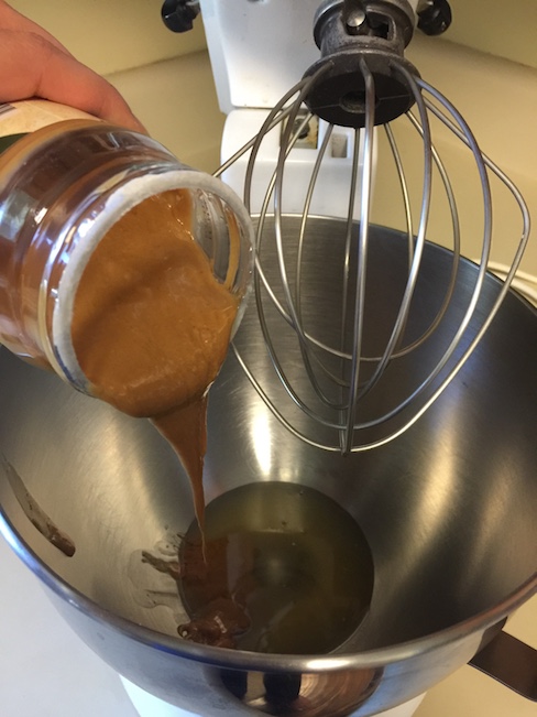 peanut butter being poured into mixing bowl