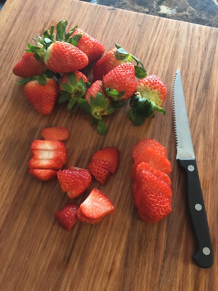 sliced strawberries on cutting board