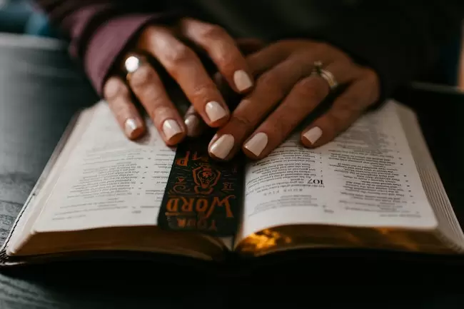 hands on top of open bible