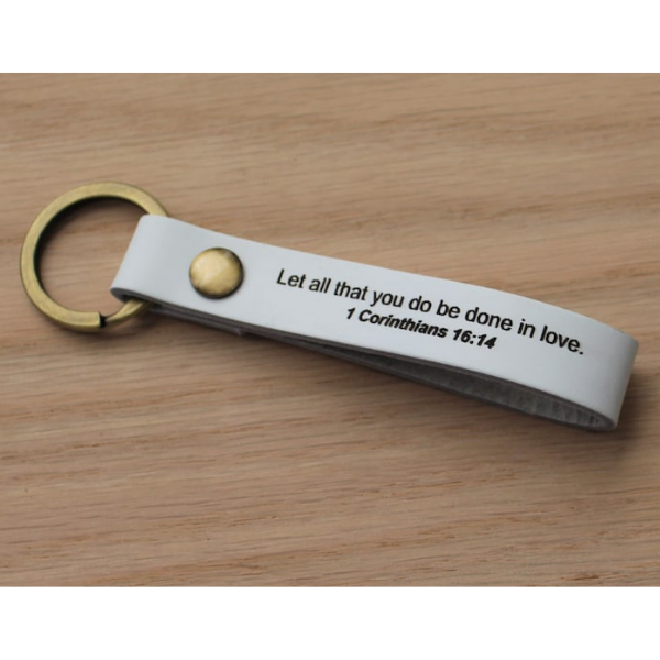 white leather keychain with verse on it