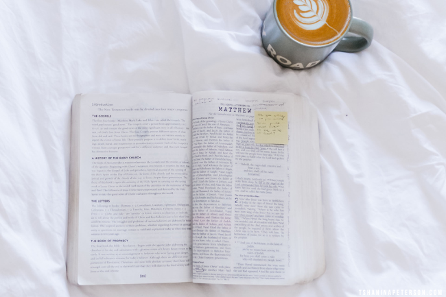 open bible and coffee sitting on a white sheet
