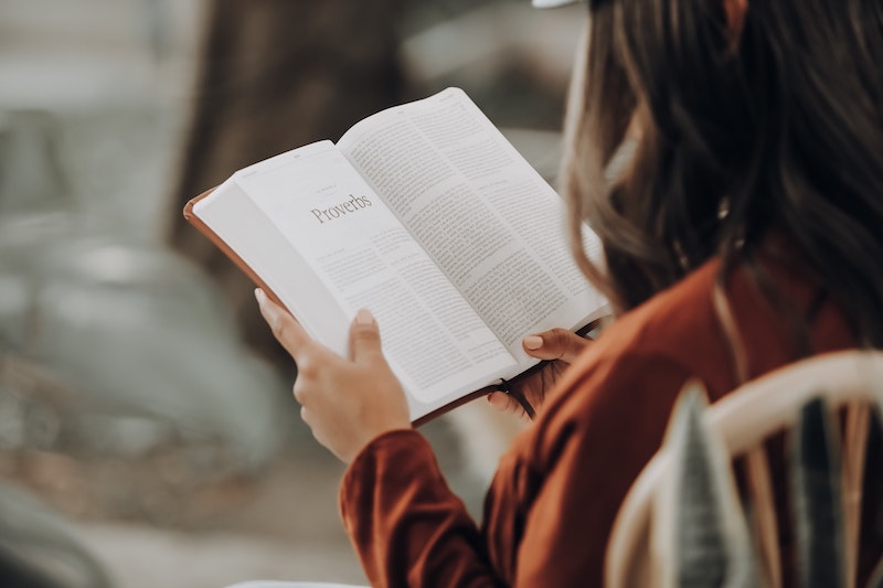 woman sitting in a chair reading her Bible