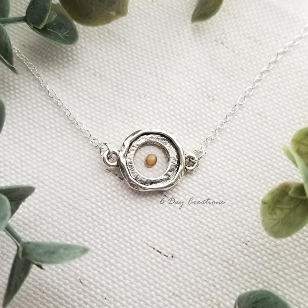 dainty round silver necklace with mustard seed in the middle
