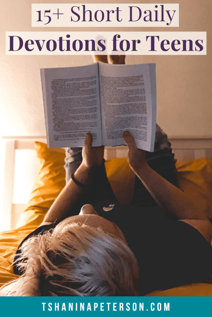 person lying on a bed with feet in the air reading a book