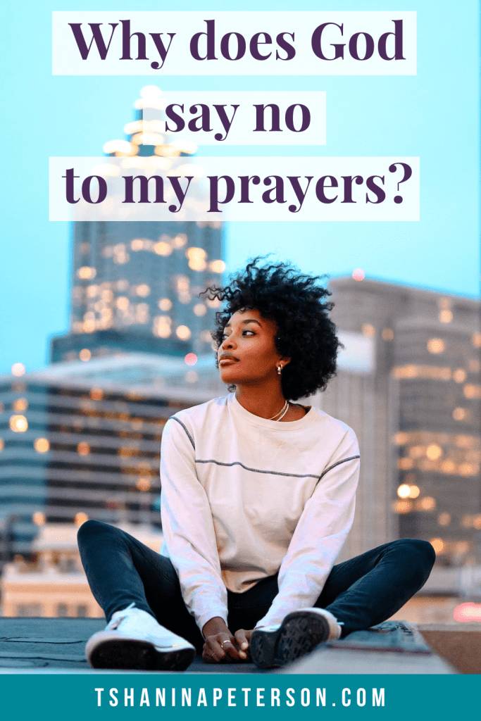 black woman witting on top of a building in front a skyscraper