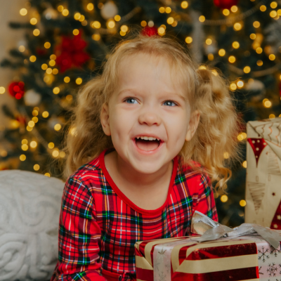 happy little girl in front of christmas tree