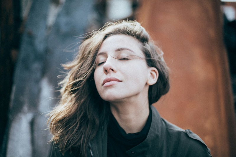 woman sitting outside, looking up and thinking