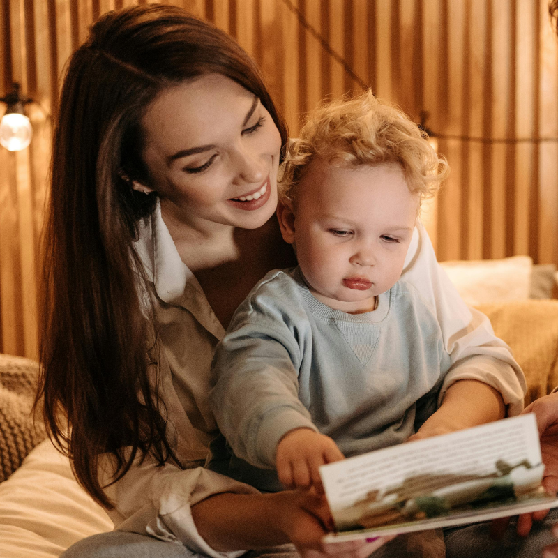 mom reading a book to her son - christian books for toddlers