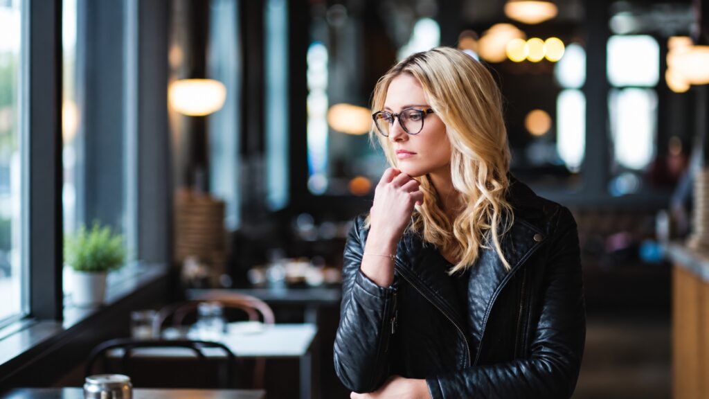 Woman sitting thoughtfully in a coffee shop